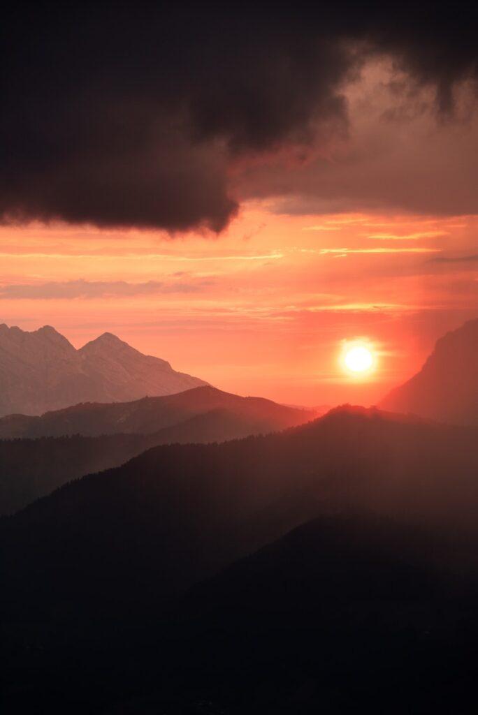 A glowing sunset paints mountains with warm hues.